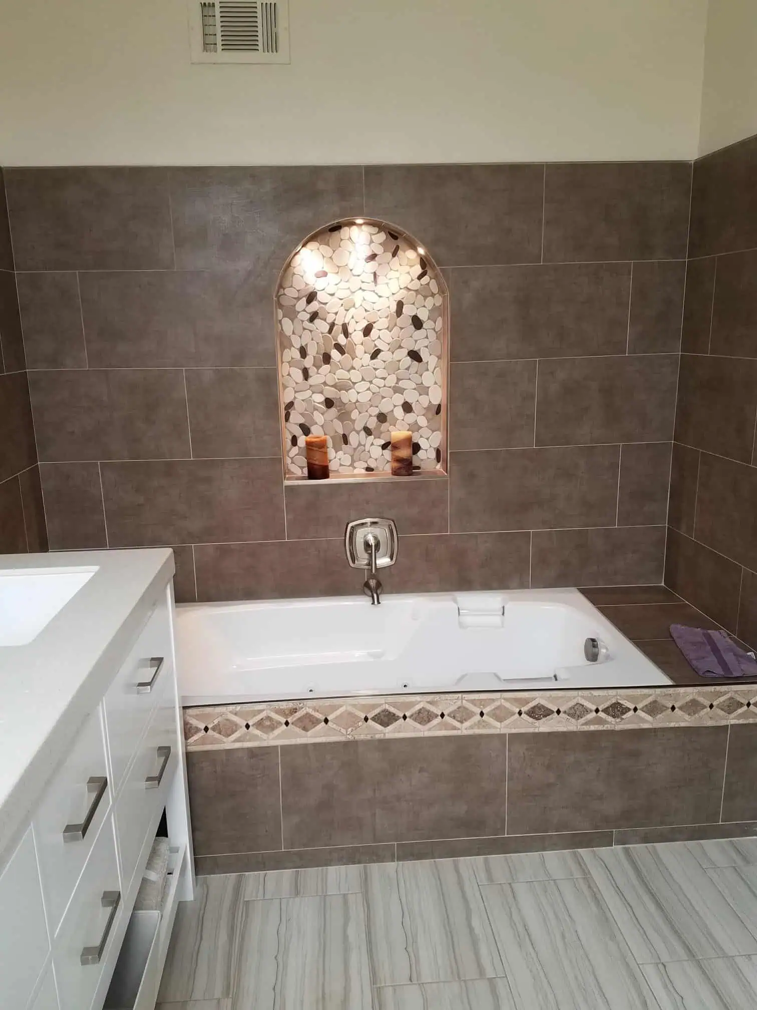 Contemporary bathroom with built-in bathtub and decorative niche.
