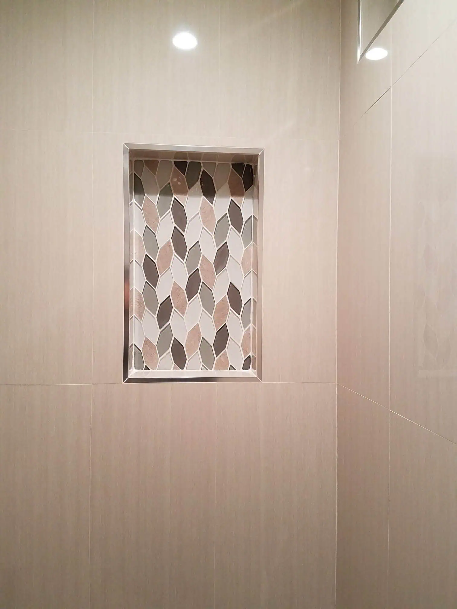 Built-in shower niche with geometric tile pattern for bathroom decor.