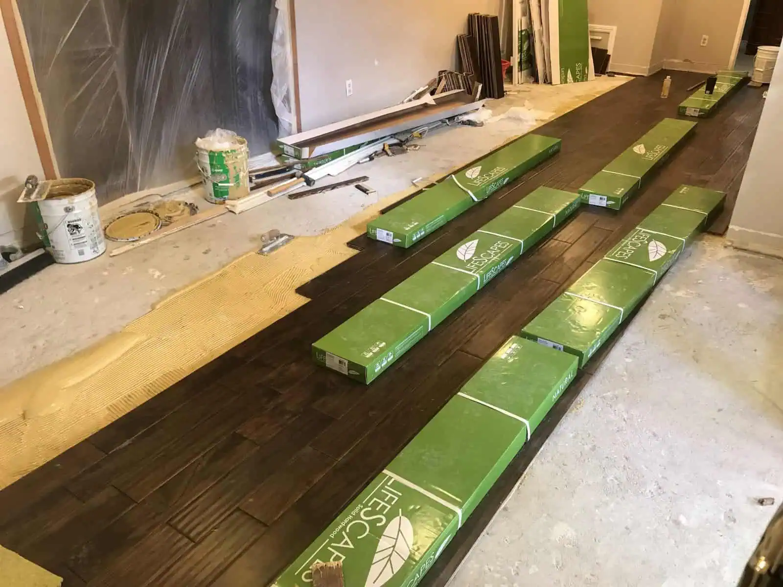 Installing dark hardwood flooring in a home renovation project.